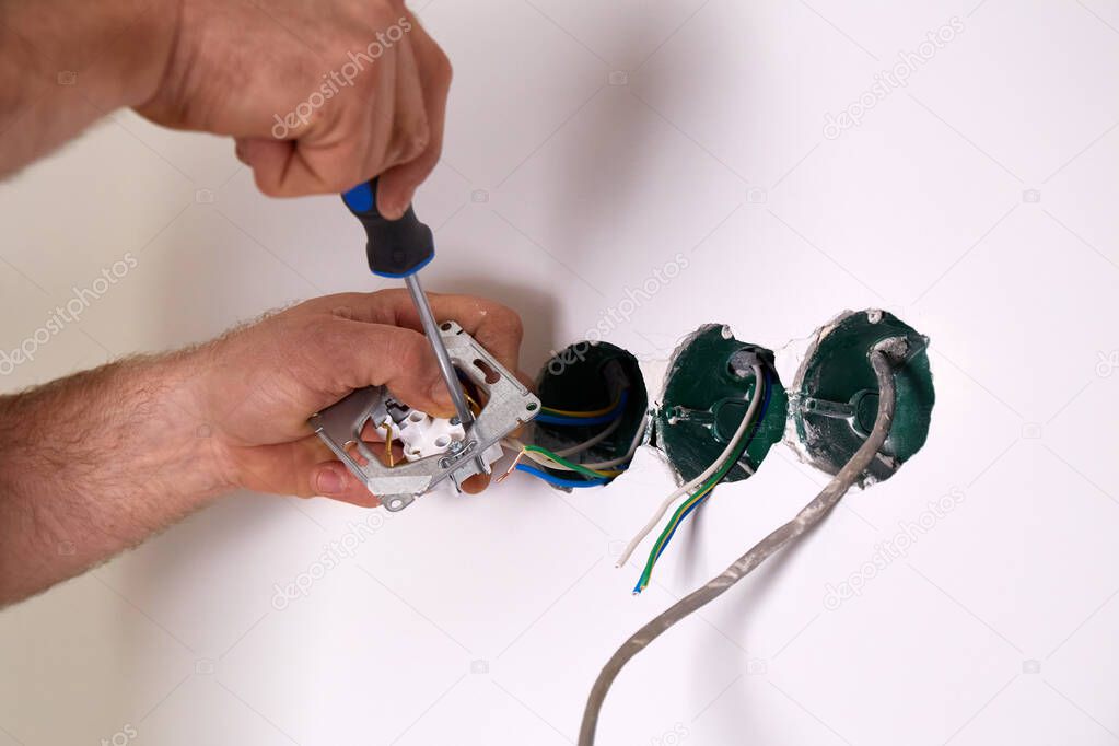Electrician reading an installation guide next to a switchboard